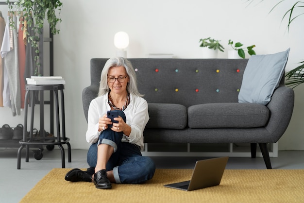 Full shot woman holding smartphone