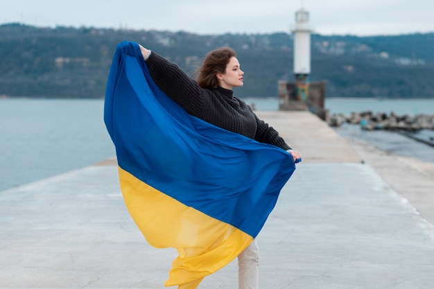 Full shot woman holding ukrainian flag