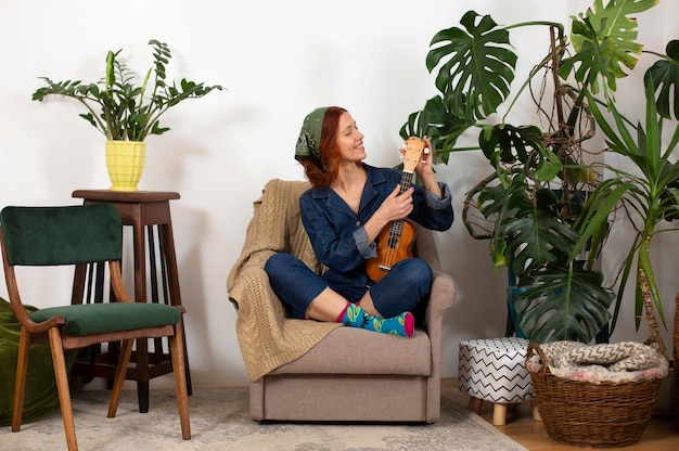 Free photo full shot woman holding ukulele