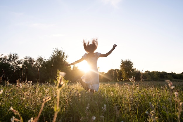 Free Photo full shot woman jumping outdoors