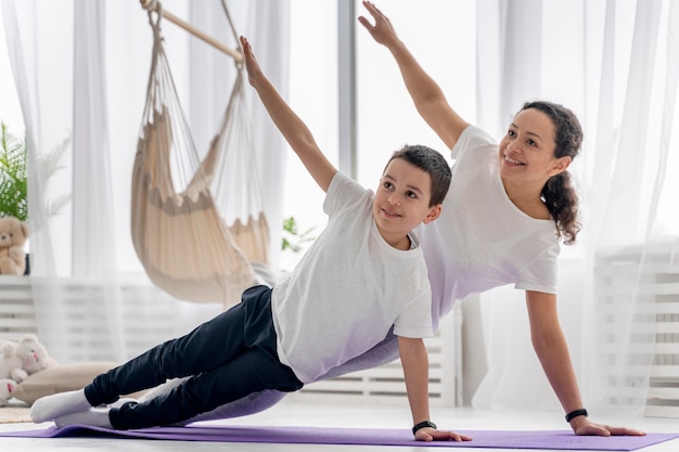 Full shot woman and kid doing sport