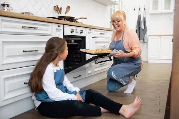 Full shot woman and kid in kitchen