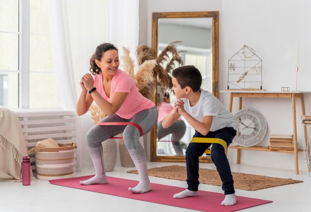 Full shot woman and kid training with resistance band