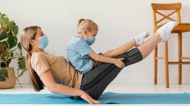 Full shot woman and kid working out