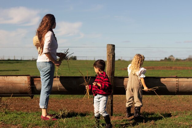 Full shot woman and kids in nature