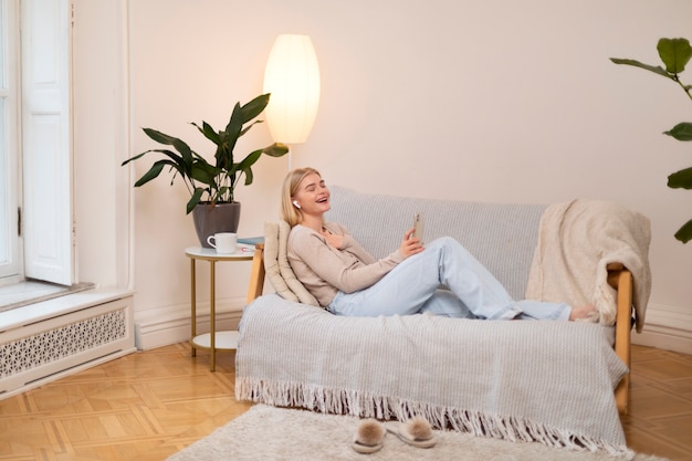 Free photo full shot woman laying on couch