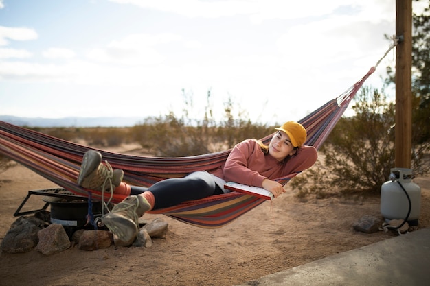 Free photo full shot woman laying on hammock