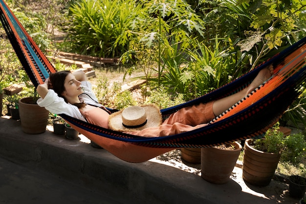 Free Photo full shot woman laying in hammock