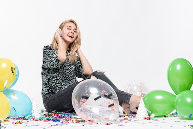 Free photo full-shot woman listening to music surrounded by balloons