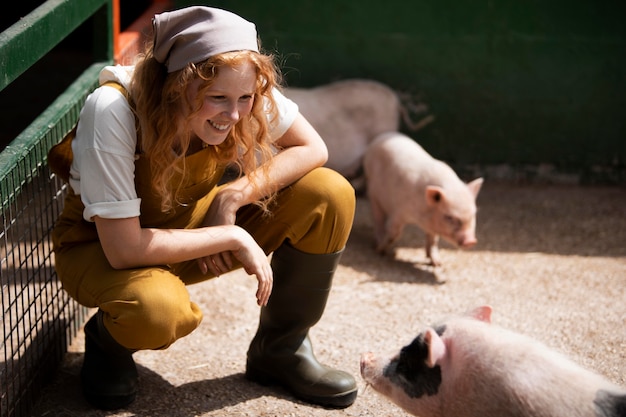 Full shot woman looking at pigs