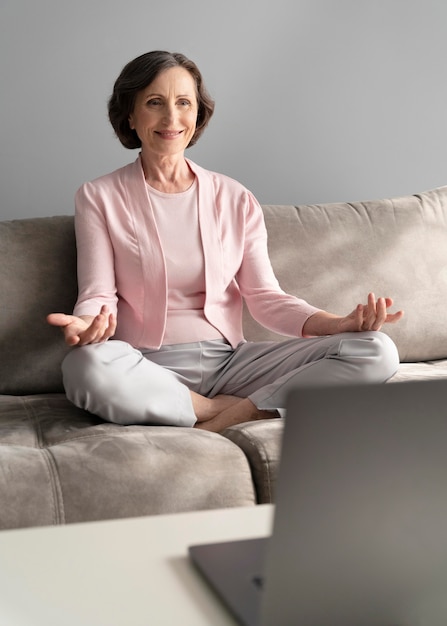 Full shot woman meditating at home