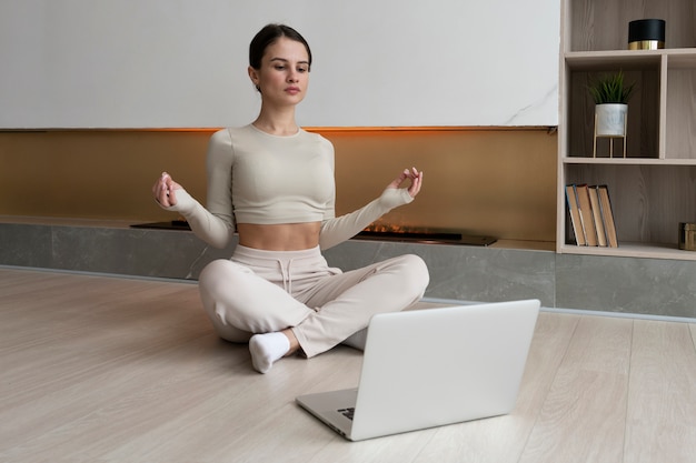 Full shot woman meditating at home