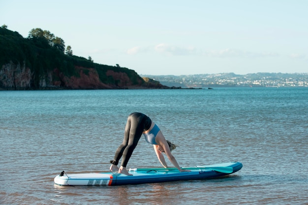 Free photo full shot woman on paddleboard