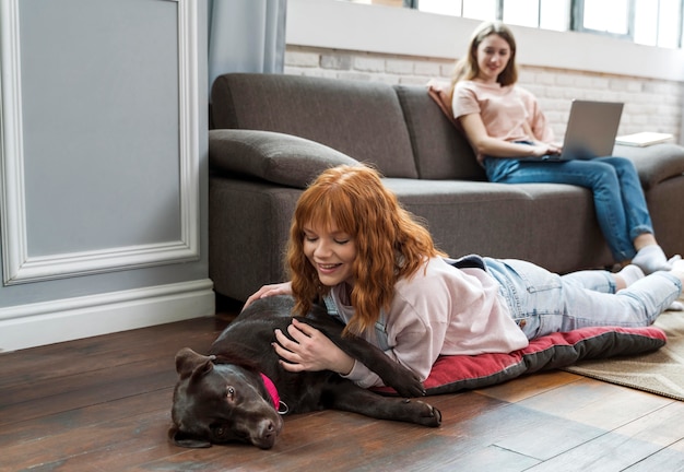 Free Photo full shot woman petting dog on floor