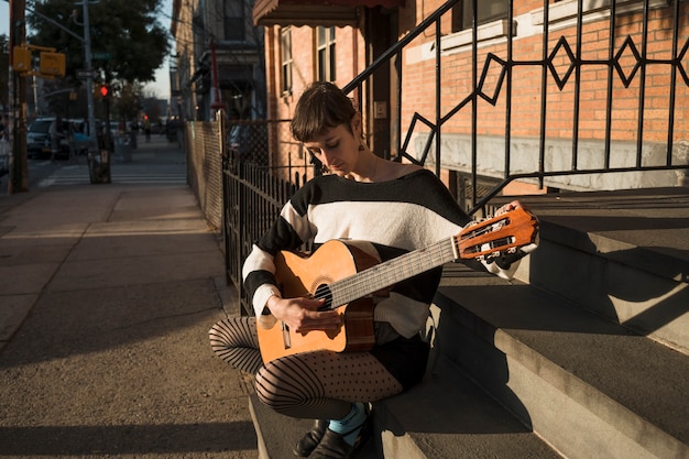 Free Photo full shot woman playing the guitar