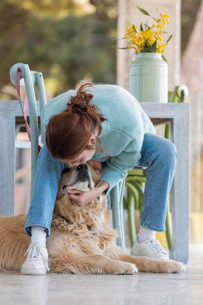 Full shot woman playing with cute dog