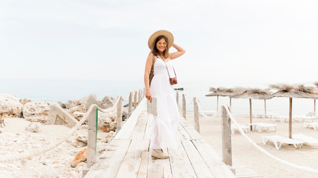 Free photo full shot woman posing at the beach