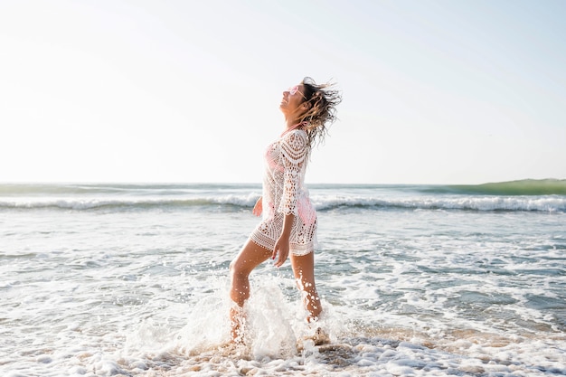 Free photo full shot woman posing at beach