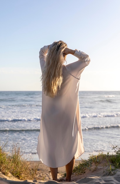 Free photo full shot woman posing at beach