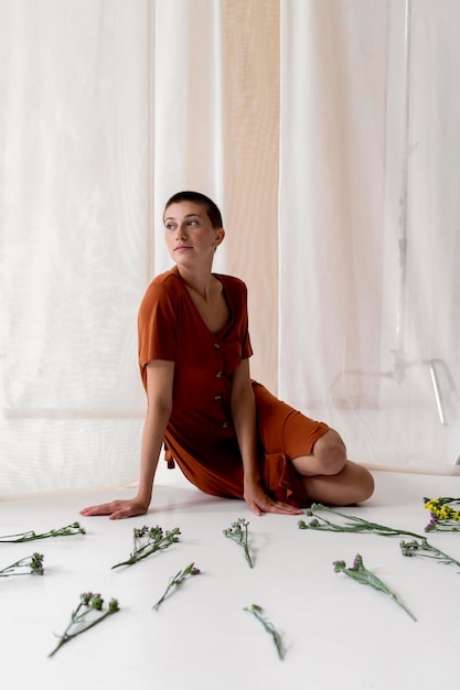 Free photo full shot woman posing with flowers