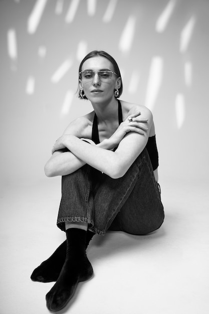 Full shot woman posing with glasses black and white