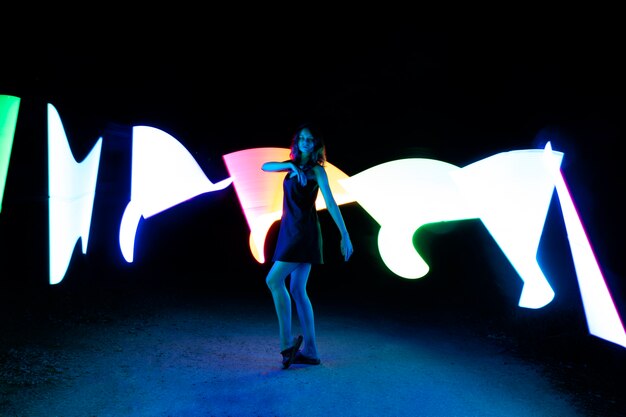 Full shot woman posing with lights outdoors