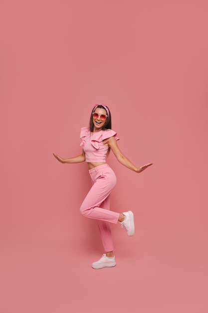 Free photo full shot woman posing with pink outfit