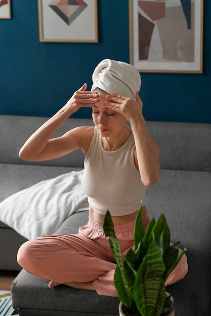 Full shot woman practicing facial yoga