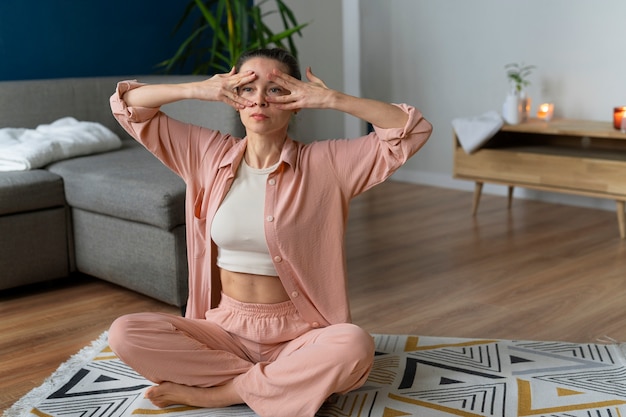 Full shot woman practicing facial yoga