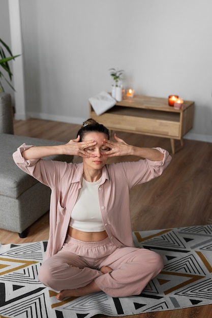 Full shot woman practicing facial yoga