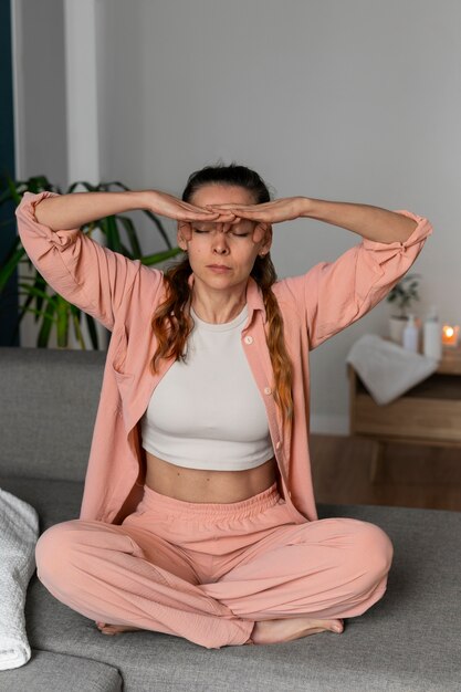 Full shot woman practicing facial yoga