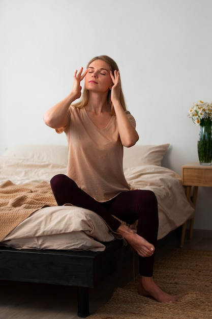 Full shot woman practicing facial yoga