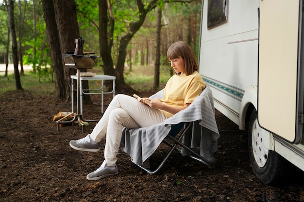 Free photo full shot woman reading in nature