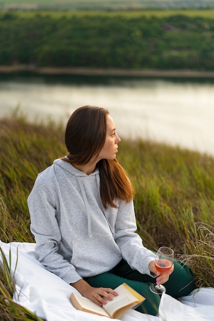 Free photo full shot woman reading in nature