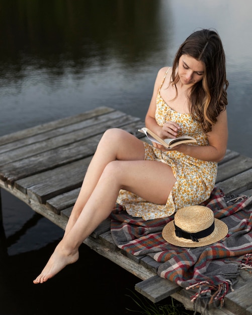 Full shot woman reading outside