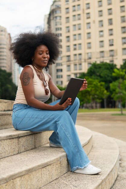 Full shot woman reading on tablet