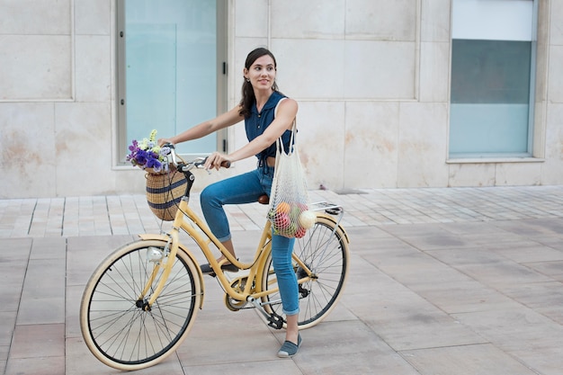 Full shot woman riding bicycle