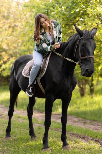 Full shot woman riding horse