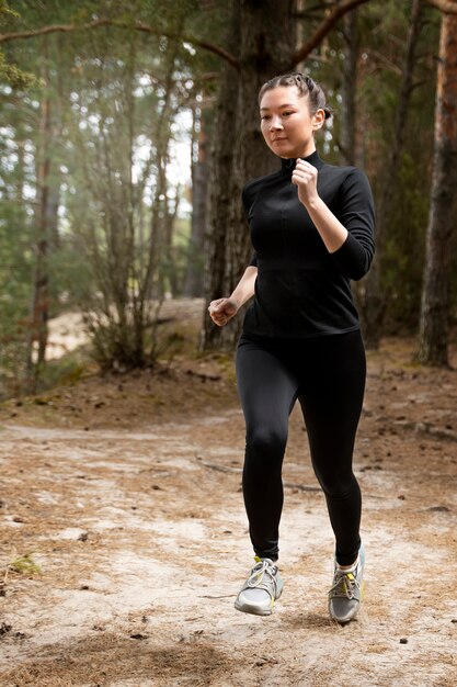 Full shot woman running outdoors