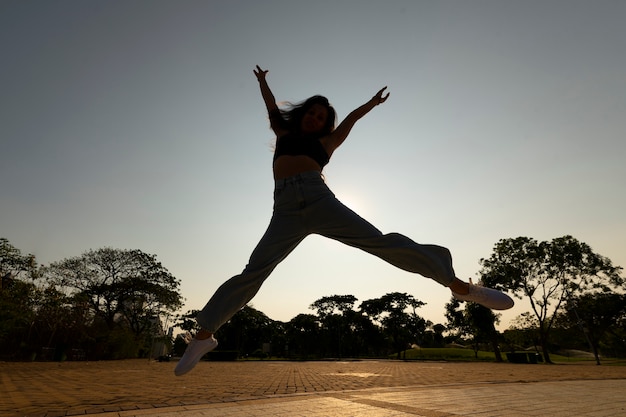 Free Photo full shot woman silhouette jumping at sunset