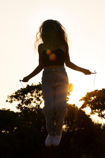 Free Photo full shot woman silhouette jumping at sunset