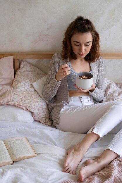 Full shot woman sitting in bed