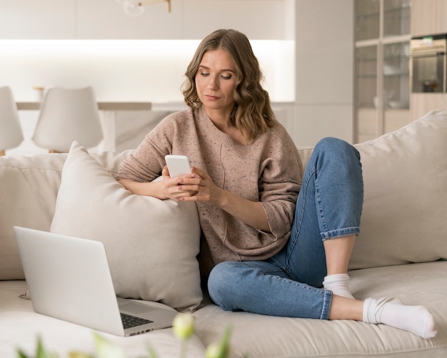 Full shot woman sitting on couch