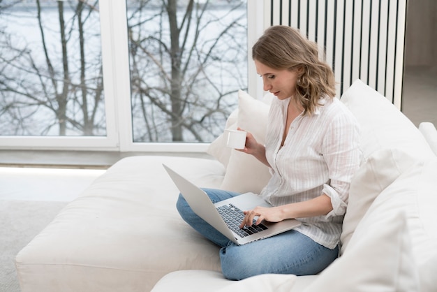 Free photo full shot woman sitting on couch