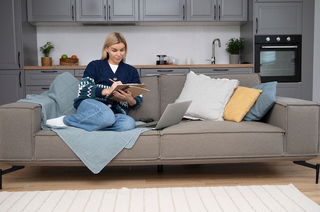 Free photo full shot woman sitting on couch