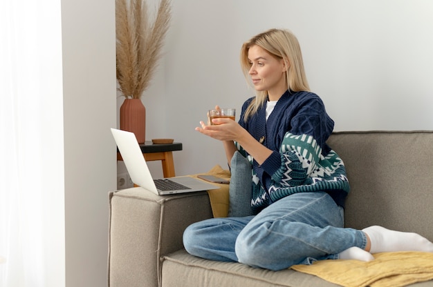 Full shot woman sitting on couch