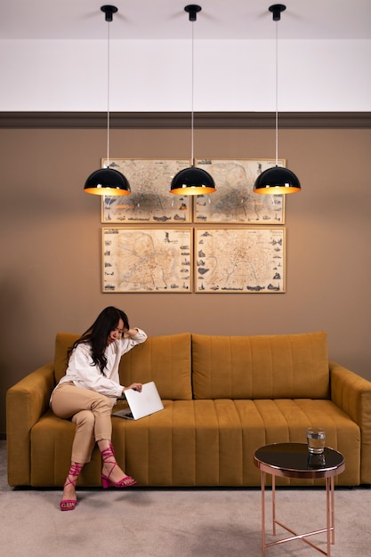 Full shot woman sitting on couch