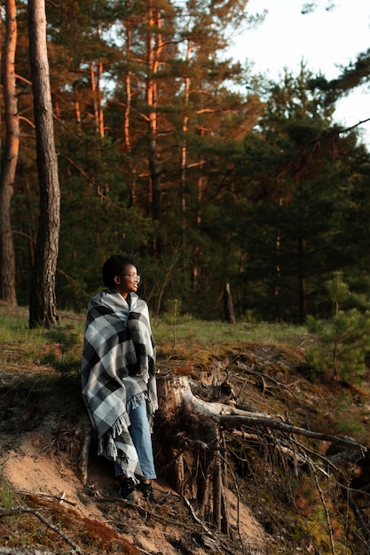 Free photo full shot woman sitting in forest