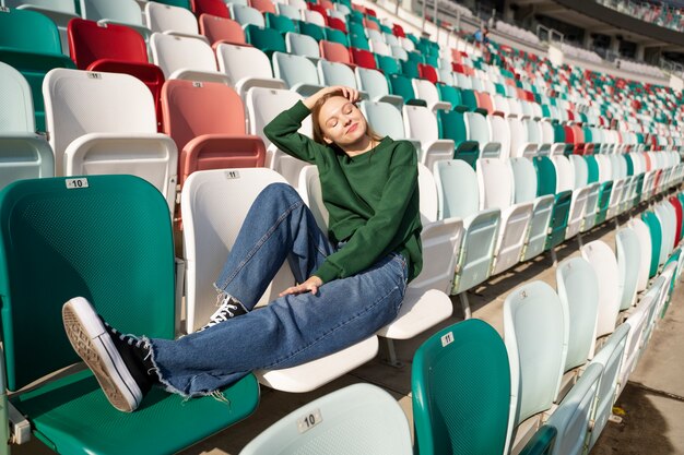 Full shot woman sitting on grandstands