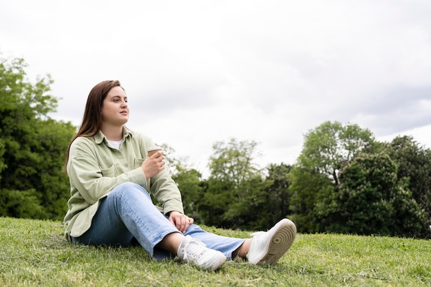 Full shot woman sitting on grass